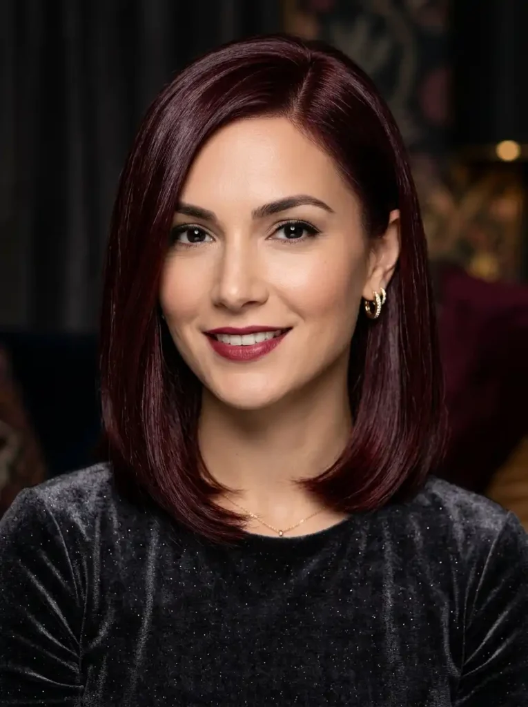 Deep garnet red hair color with jewel-toned dark red on sleek polished hair